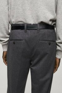 Graue Wollhose mit glatter Textur, ausgestattet mit einem schwarzen Ledergürtel, zwei Gesäßtaschen mit schwarzen Knöpfen und einer maßgeschneiderten Passform.
