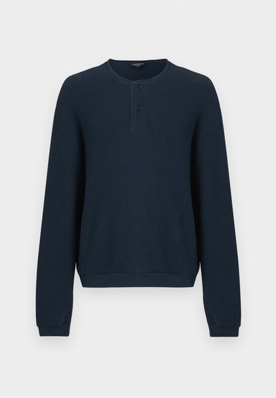 Μακρυμάνικο πουλόβερ σε ναυτικό μπλε με υφή ριμπ ύφανσης. Διαθέτει λαιμόκοψη τύπου crew και τρεις κουμπότρυπες μπροστά. Οι μανσέτες και το τελείωμα είναι μονόχρωμα.