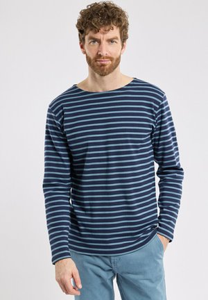 Langærmet skjorte i marineblå og lyseblå striber med bådformet halsudskæring. Blødt stof med en afslappet pasform og slidser i siden ved kanten.