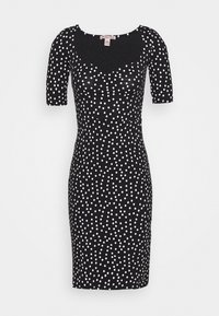 Svart klänning med korta ärmar, med en figurnära silhuett och spridda vita prickar. Mjuk tyg med en slät yta och rundad halsringning.