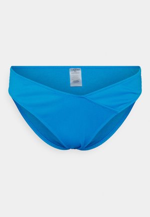 Fato de banho azul em tecido canelado, com um design de frente cruzada e uma etiqueta ao centro, apresentando uma textura suave.