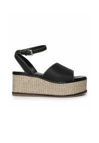 Sandalias de plataforma de cuero negro con puntera abierta, tira en el tobillo y textura de yute trenzado en la suela de cuña. Costuras blancas realzan el diseño.