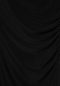 Black fabric with soft folds and draping, creating gentle shadows and curved lines across the surface.