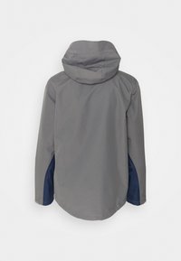Veste grise à capuche avec des accents de panneaux bleu marine sur les manches basses, vue de dos sur fond blanc.