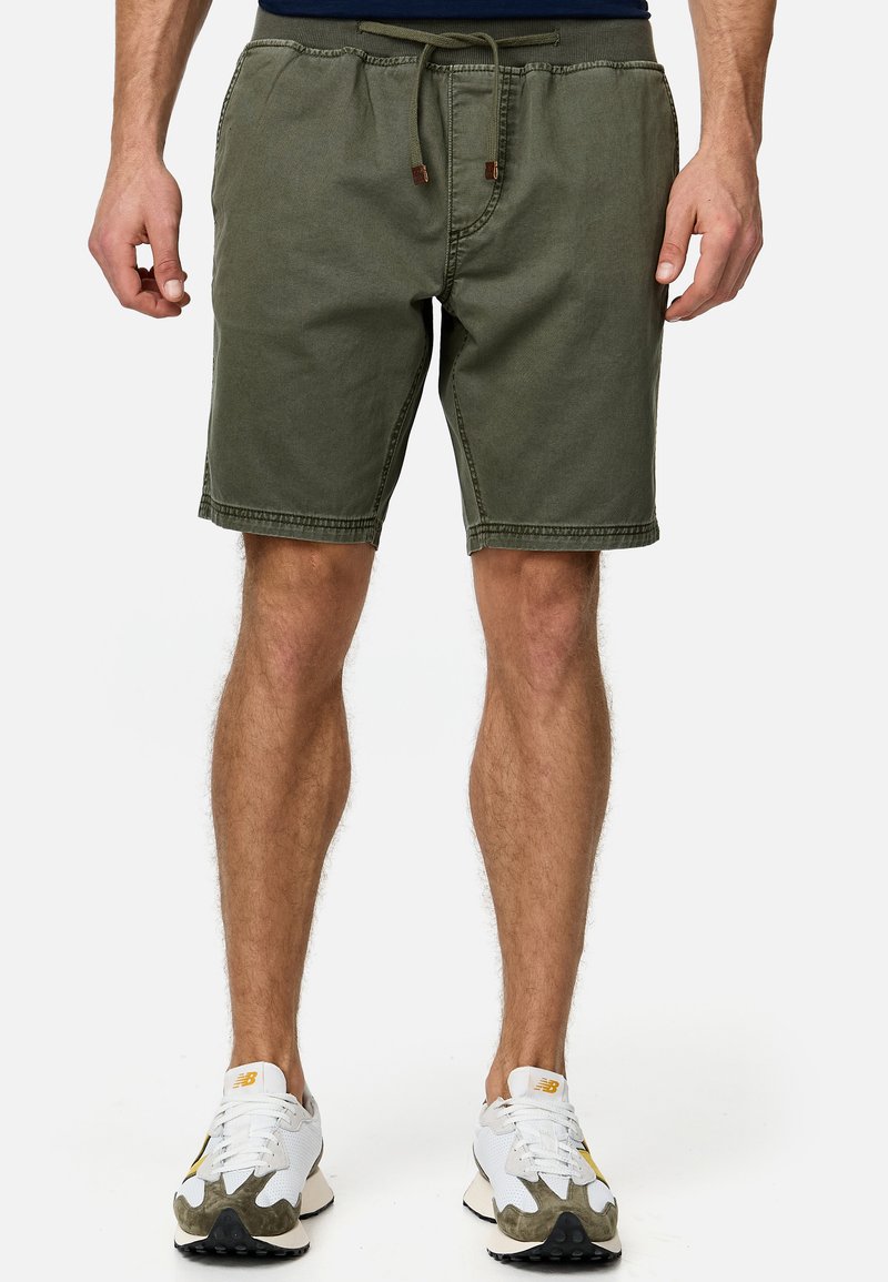 Shorts vert olive avec une taille élastique et un cordon de serrage, dotés de poches latérales et d'un coupe décontractée, fabriqués en tissu doux et durable.