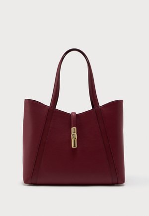 Burgundy leather tote bag with two handles and a gold clasp closure on front against white background.