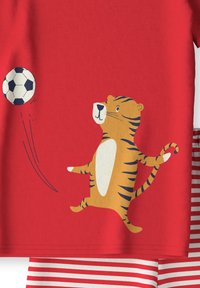 Rode katoenen T-shirt met een cartoon tijger en een grafisch ontwerp van een voetbalsbal. Inclusief rood-wit gestreepte shorts als outfitdetail.