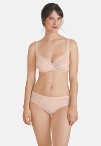 Reggiseno in pizzo rosa chiaro e mutandine coordinate con motivo floreale, spalline regolabili e bordi scallopati. Texture liscia e dettagli delicati.