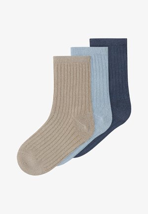 Τρία ριγωτά κάλτσες για πλήρωμα σε μπεζ, ανοιχτό μπλε και σκούρο μπλε, τοποθετημένα αλληλοκαλυπτόμενα σε λευκό φόντο.