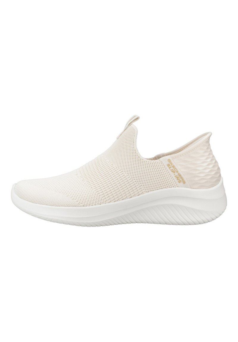 Slip-on treningssko i beige stoff med en teksturert, pustende mesh-overdel og en hvit såle med et bølgemønster for grep.