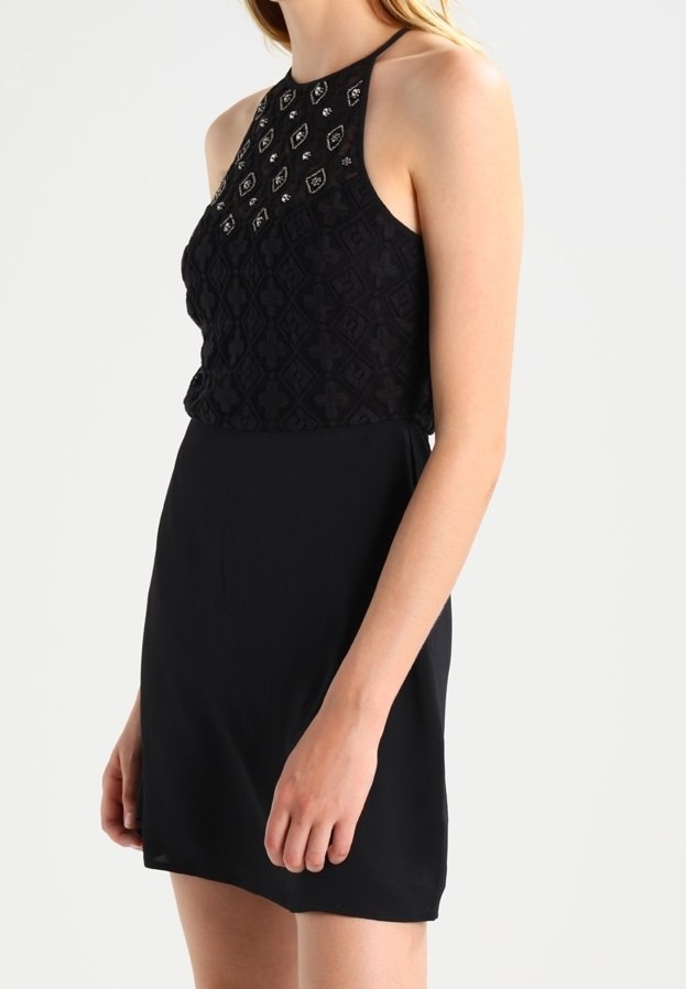 Black dress featuring a textured, embroidered halter top with decorative accents and a smooth, fitted skirt.