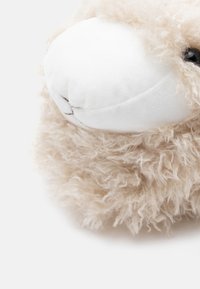 Mīkstā aita rotaļlieta ar pūkainu bēšīgu vilnu, baltu seju un melnām acīm. Vietām ir apaļa, mīksta forma un izsmalcināta sejas detaļošana.