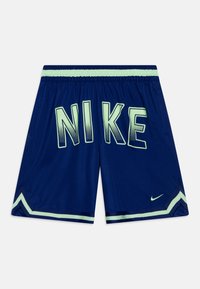 Pantalones cortos de Nike en azul marino con acentos en verde claro. Presentan letras en negrita "NIKE" en la parte posterior, cinturilla elástica y tejido texturizado.