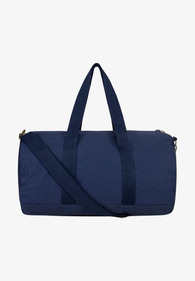 Marineblå duffelbag laget av slitesterkt stoff med to topphåndtak og en avtakbar skulderstropp. Den har glidelåsforsegling og en jevn tekstur.
