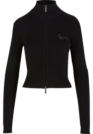 Sweat à zip noir côtelé avec un col haut, des manches longues et une coupe ajustée. Il arbore un petit logo brodé sur la poitrine.