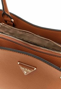 Sac à main en simili cuir marron texturé avec des bordures noires. Comprend une fermeture zippée et un détail de logo triangulaire en ton or. L'intérieur est doublé de tissu.