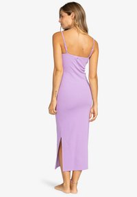 Lila ärmelloses Maxikleid, weicher Stoff, figurbetontes Design, seitliche Schlitze, verstellbare Träger, Knopfdetails am Rücken.