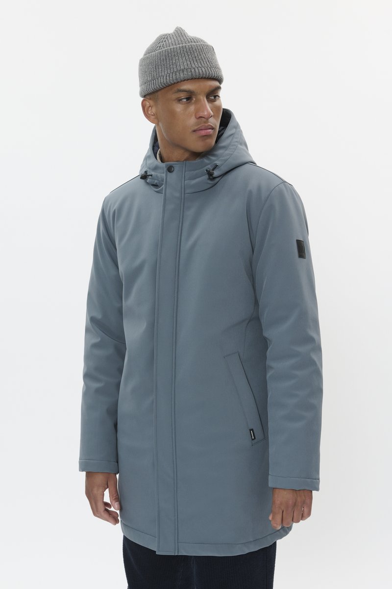 Siv parka, odporna na vodo, s oblikovanim kapuco, zapiranjem na zadrgo in stranskimi žepi. Gladek zunanjost z majhnim logotipom na levem rokavu.