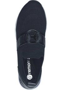 Schwarzer gestrickter Sportschuh mit einem glänzenden schwarzen Band und Logo. Verfügt über eine gepolsterte Sohle und ein Obermaterial aus Stoff, das ein leichtes Anziehen ermöglicht.