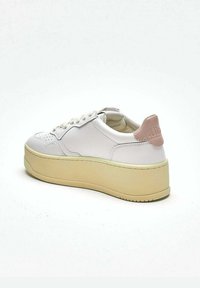 Sneaker in pelle bianca con punta arrotondata, suola platform e dettaglio rosa sul tallone. I lacci corrono lungo la parte frontale con dettagli traforati.