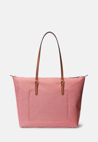Różowa torba typu tote z płótna z dwoma brązowymi skórzanymi uchwytami, z teksturowaną kieszenią z przodu i zamkiem błyskawicznym na górze.