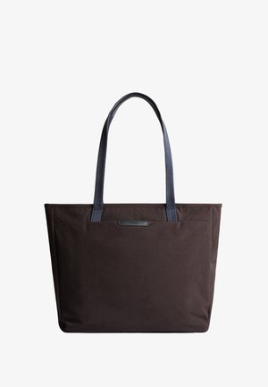 Sac fourre-tout en tissu marron avec deux poignées bleues, forme rectangulaire, texture lisse et petit détail de logo à l'avant.