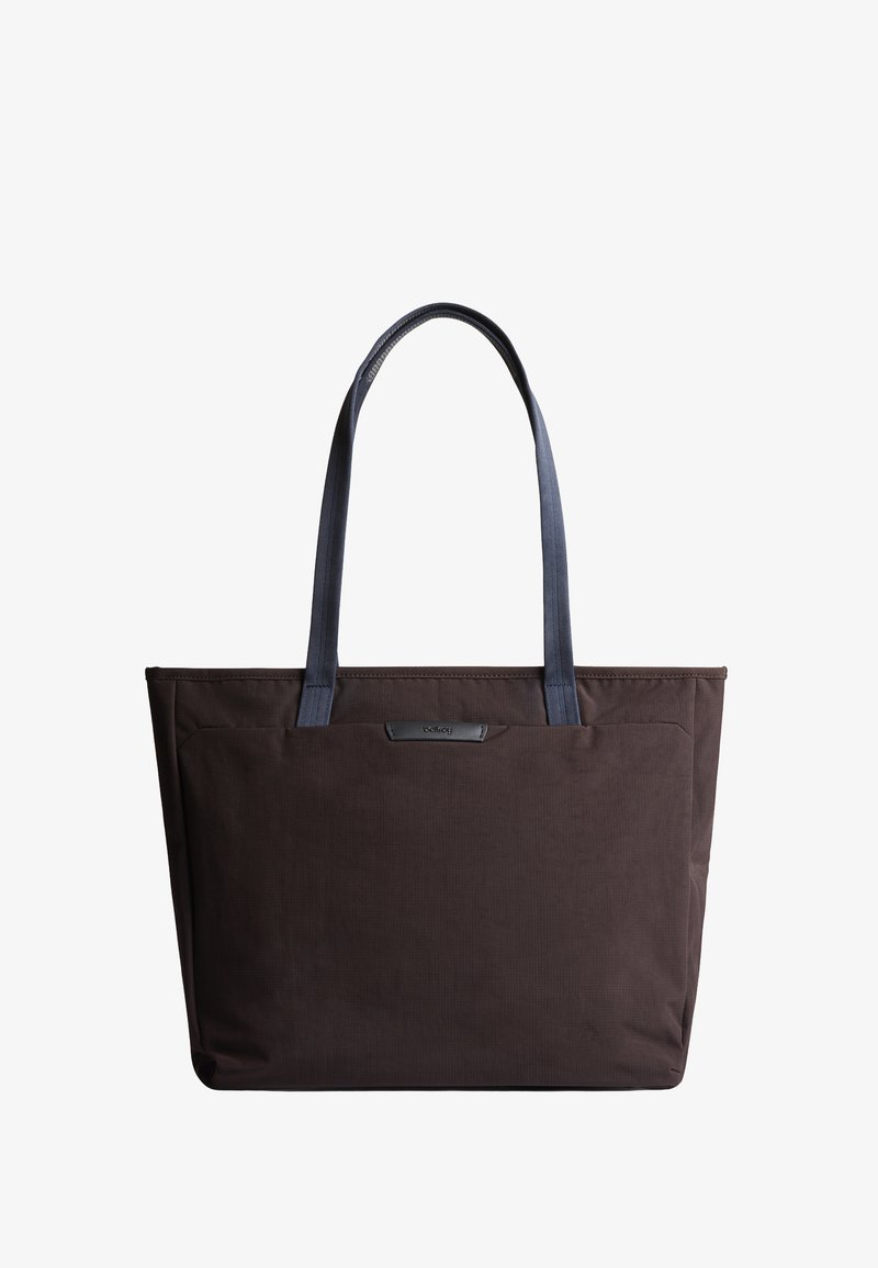 Sac fourre-tout en tissu marron avec deux poignées bleues, forme rectangulaire, texture lisse et petit détail de logo à l'avant.