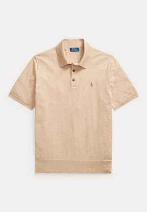 Beżowa koszulka polo z krótkim rękawem, z dwoma guzikami, kołnierzykiem i małym wyszywanym logo na lewej piersi.