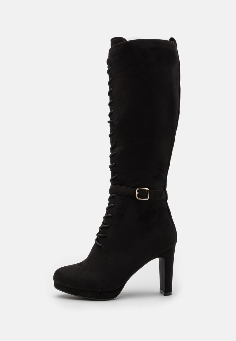 Bota alta de ante negra con detalle de cordones y acento de hebilla dorada. Presenta una punta redondeada y un alto tacón de bloque. Textura suave.