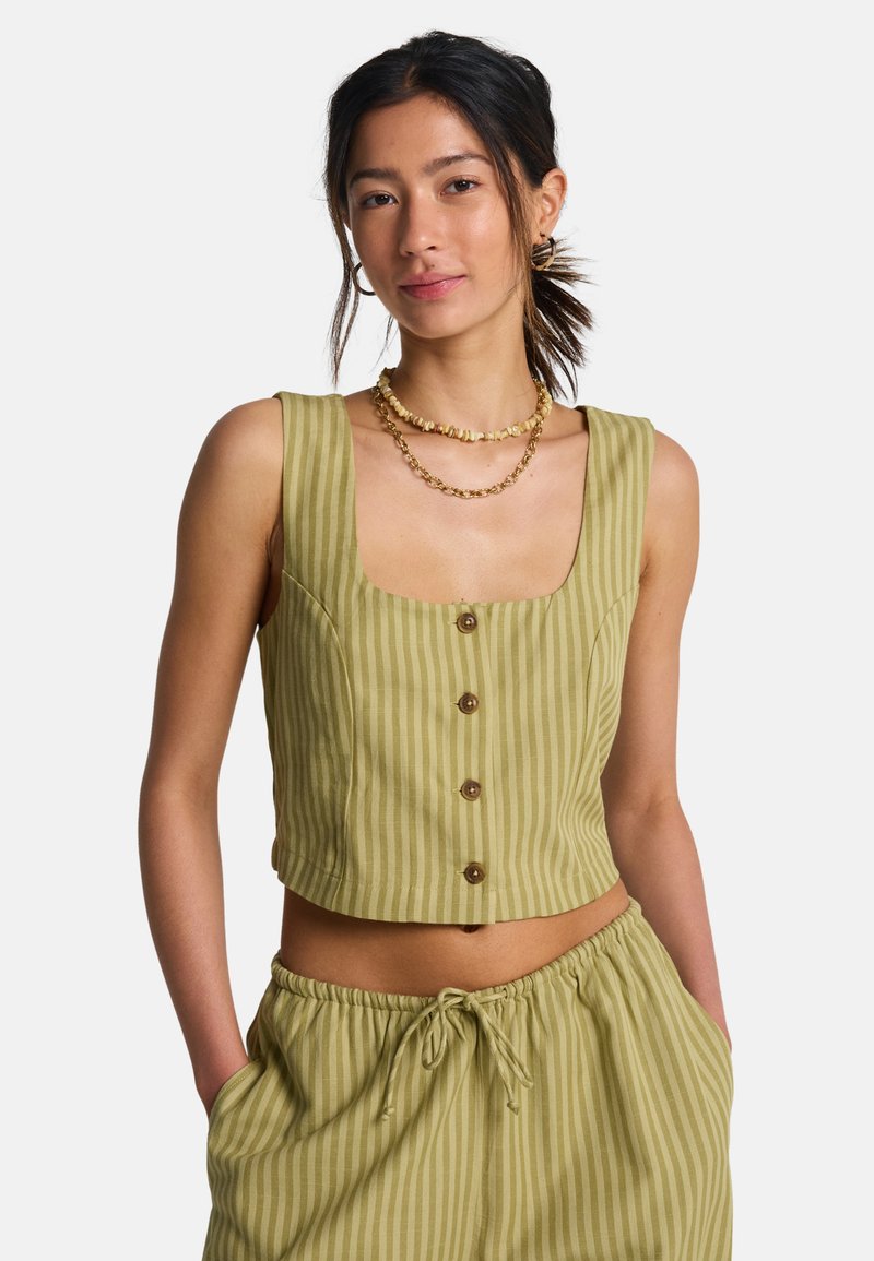 Πράσινο ριγέ κοντό τοπ με τετράγωνο ντεκολτέ, πέντε καφέ κουμπιά στο μπροστινό μέρος και εφαρμοστή σχεδίαση, συνδυασμένο με αντίστοιχο φαρδύ παντελόνι.