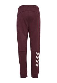 Mörkröda atletiska byxor med en avsmalnande design, som har en mjuk yta, elastisk midja och ett vitt chevronmönster på sidan.