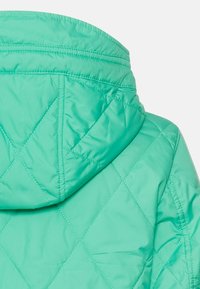 Quilted, turkis hoodiejakke med en glat, blank overflade. Har en høj krave og diagonale syninger på stoffet.