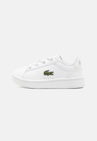 Vita sneakers med en slät läderöverdel, platta snören och en grön krokodil-logo på sidan. Gummisula med en ren design.