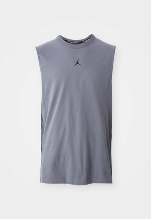 Camiseta sin mangas de algodón gris con cuello redondo; presenta un logo negro de Jumpman en el centro delantero, textura suave y corte relajado.