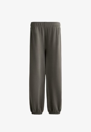 Dunkelolivgrüne Jogginghose aus weichem, leichtem Stoff. Verfügt über einen elastischen Bund und elastische Bündchen an den Knöcheln. Glatte Textur.