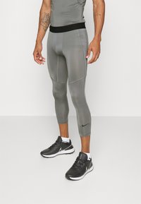 Nike Performance - Športne hlače dolžine 3/4 - smoke grey/black Miniaturna slika 1