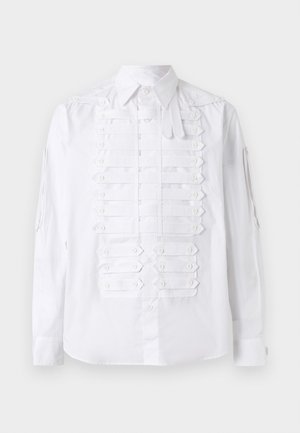 White long-sleeve shirt with a classic collar and decorative buttoned fabric strips on the front and sleeves.