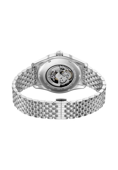 Montre en acier inoxydable avec un bracelet argenté et un boîtier rond. Fond transparent dévoilant le mouvement. Finition polie et boucle réglable.