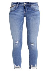 Vaqueros ajustados en denim azul medio con detalles desgastados. Presenta desgastes en las rodillas y un ligero desvanecimiento para aportar textura. Diseño clásico de cinco bolsillos.