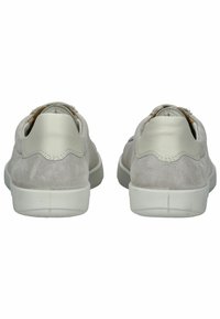 Hellgraue Wildledersneaker mit einem glatten cremefarbenen Akzent an der Ferse, die ein minimalistisches Design und eine weiße Gummisohle aufweisen.