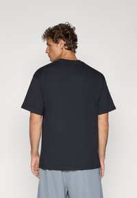 Sort bomulds T-shirt med korte ærmer og rund halsudskæring, der har en afslappet pasform og et enkelt design uden yderligere mønstre eller detaljer.