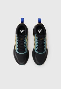 Baskets de sport noires avec des accents teal et dorés, une languette rembourrée et une semelle texturée. Présentent une languette de traction bleue et un logo à trois bandes sur le côté.