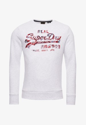 Sweat-shirt gris clair à manches longues avec logo "SuperDry" aux motifs rouges, bleus et blancs, accompagné de texte japonais sur la poitrine.