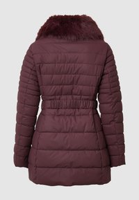 Doudoune bordeaux foncé avec un col en fausse fourrure, un design matelassé, une taille cintrée et des manches longues. Texture lisse sans éléments métalliques visibles.