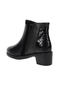 Botas negras hasta el tobillo con parte superior de cuero suave, un acento de charol texturizado en el talón y cremalleras laterales para un fácil uso. Diseño de tacón cuadrado.