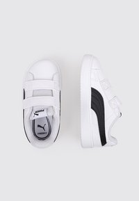 Sneakers bianchi con accenti neri, parte superiore in materiale sintetico, cinturini con chiusura a strappo, punta rotonda, suola testurizzata e branding PUMA sulla linguetta.