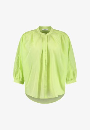 Lime spalvos, lengvas bluzonas su aukštu apykakle, pūstomis rankovėmis, mygtukų užsegimu ir laisvu siluetu. Minkšta tekstūra su šiek tiek blizgiu paviršiumi.