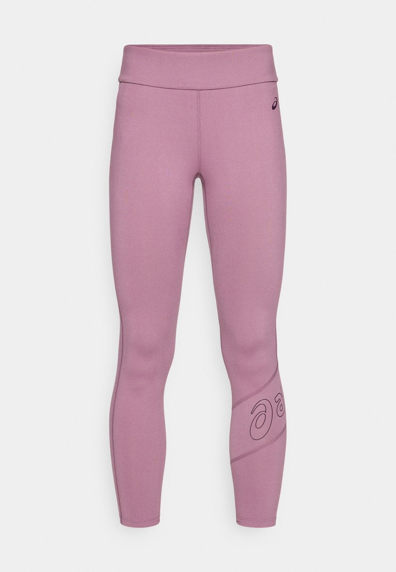 Leggings ajustés en tissu lavande doux avec une taille haute et un accent de logo noir sur le bas de la jambe gauche. Texture lisse, sans motifs.