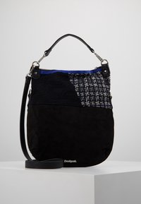 Czarna zamszowa torebka na ramię z teksturowaną tkaninową wstawką, niebieskimi akcentami i srebrnymi okuciami. Posiada czarny pasek i zamek błyskawiczny.