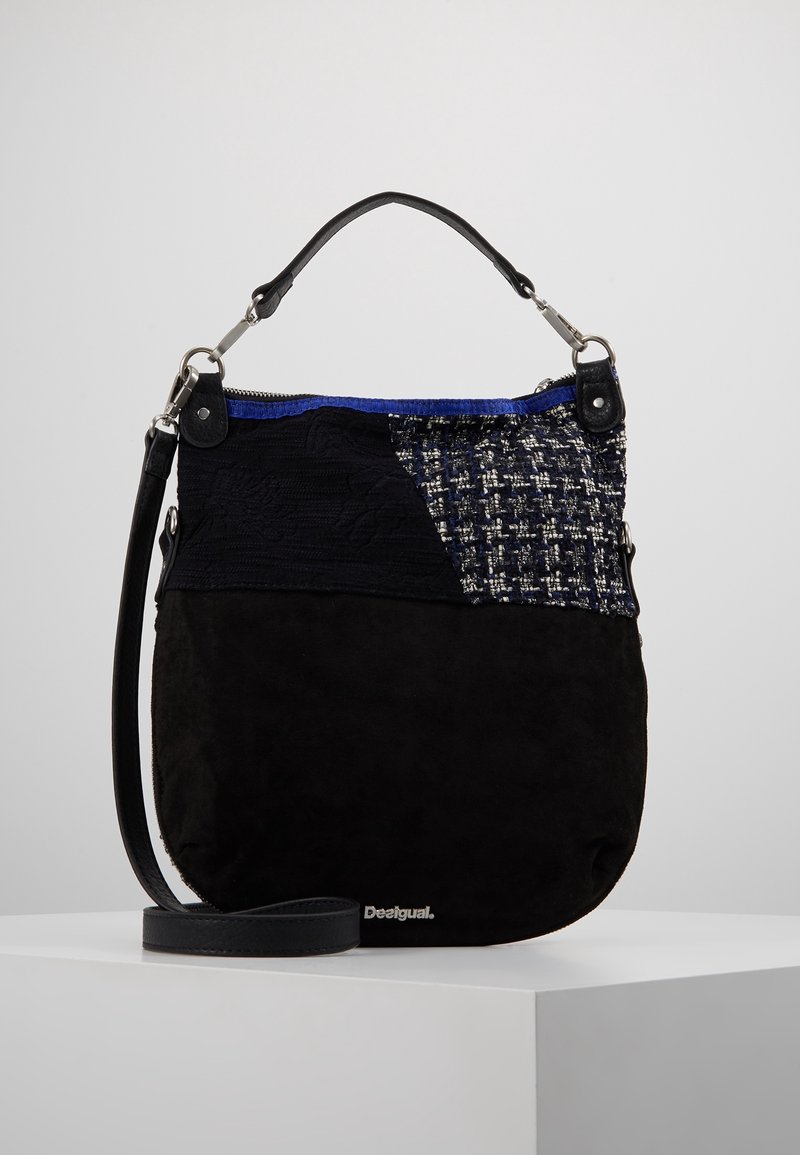 Czarna zamszowa torebka na ramię z teksturowaną tkaninową wstawką, niebieskimi akcentami i srebrnymi okuciami. Posiada czarny pasek i zamek błyskawiczny.